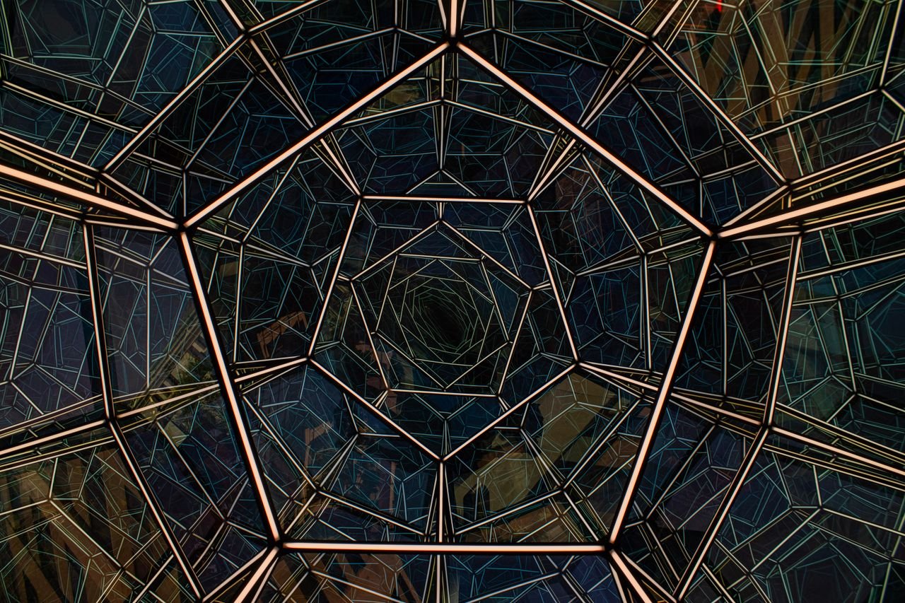 Services Abstract view of an intricate geometric glass roof from below, showcasing modern architectural design in Washington, D.C.